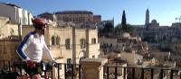 Cyclist viewing the historic cave dwellings in the Sassi di Matera | Kate Baker