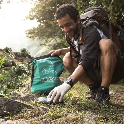 Traveller collecting litter along wilderness trails, part of our 10 Pieces litter collection program